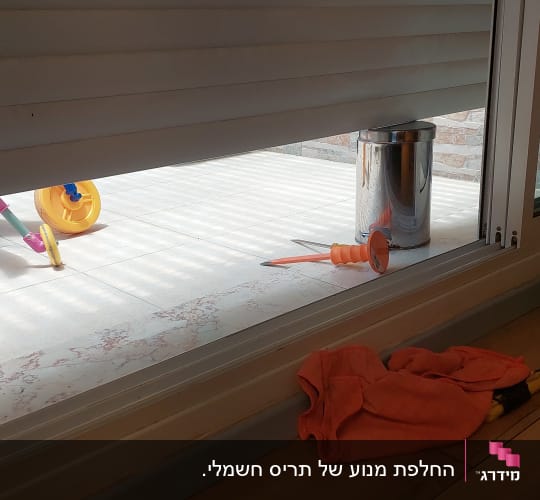 תריסים חצי סגורים עם חפצים על הרצפה
